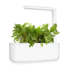 Jardin intelligent Click & Grow cultivant des plants d’oseille verte dans une jardinière d’intérieur blanche avec bras d’éclairage