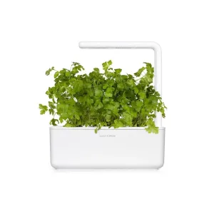 Click & Grow Smart Garden-persiljerefill i en vit örtkruka för inomhusbruk med odlingslampa