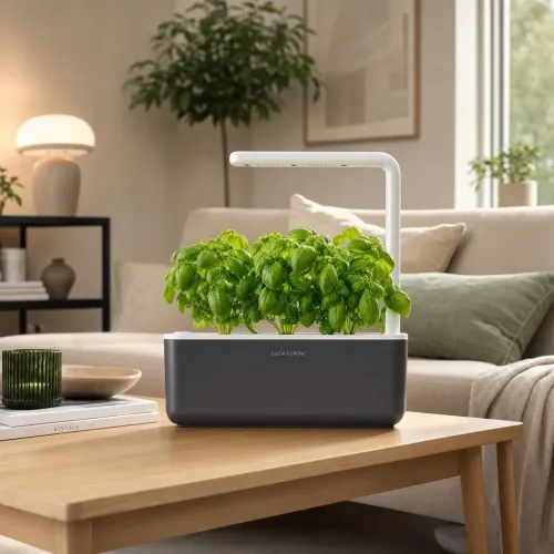 Click & Grow Smart Garden 3 indoor herb garden with LED light and leafy plants on a coffee table
