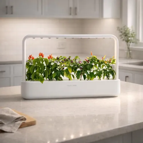 Click & Grow Smart Garden 9 inomhusträdgård för bänkskiva med växande örter och färgglada paprikor i en vit ram