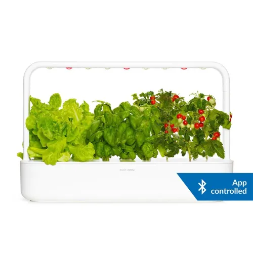 Click and Grow Smart Garden 9 Pro i vit plast med LED-bygel, nio plantplatser och grödor; Bluetooth-märke i hörnet till höger.